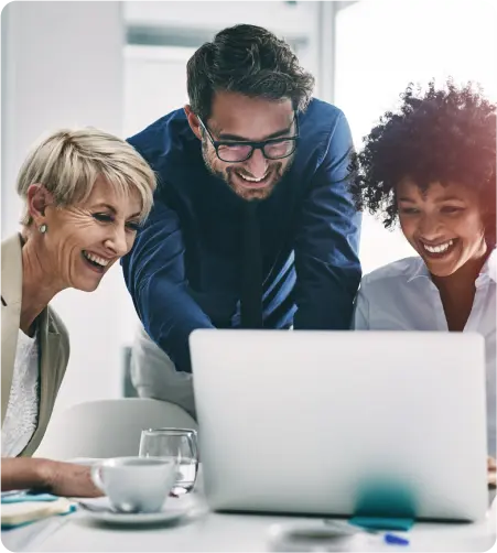 Three business professionals collaborating while examining a laptop screen in a modern office setting.