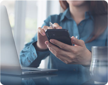 A woman checking her email on a smartphone, focused and engaged with the device in a modern setting.